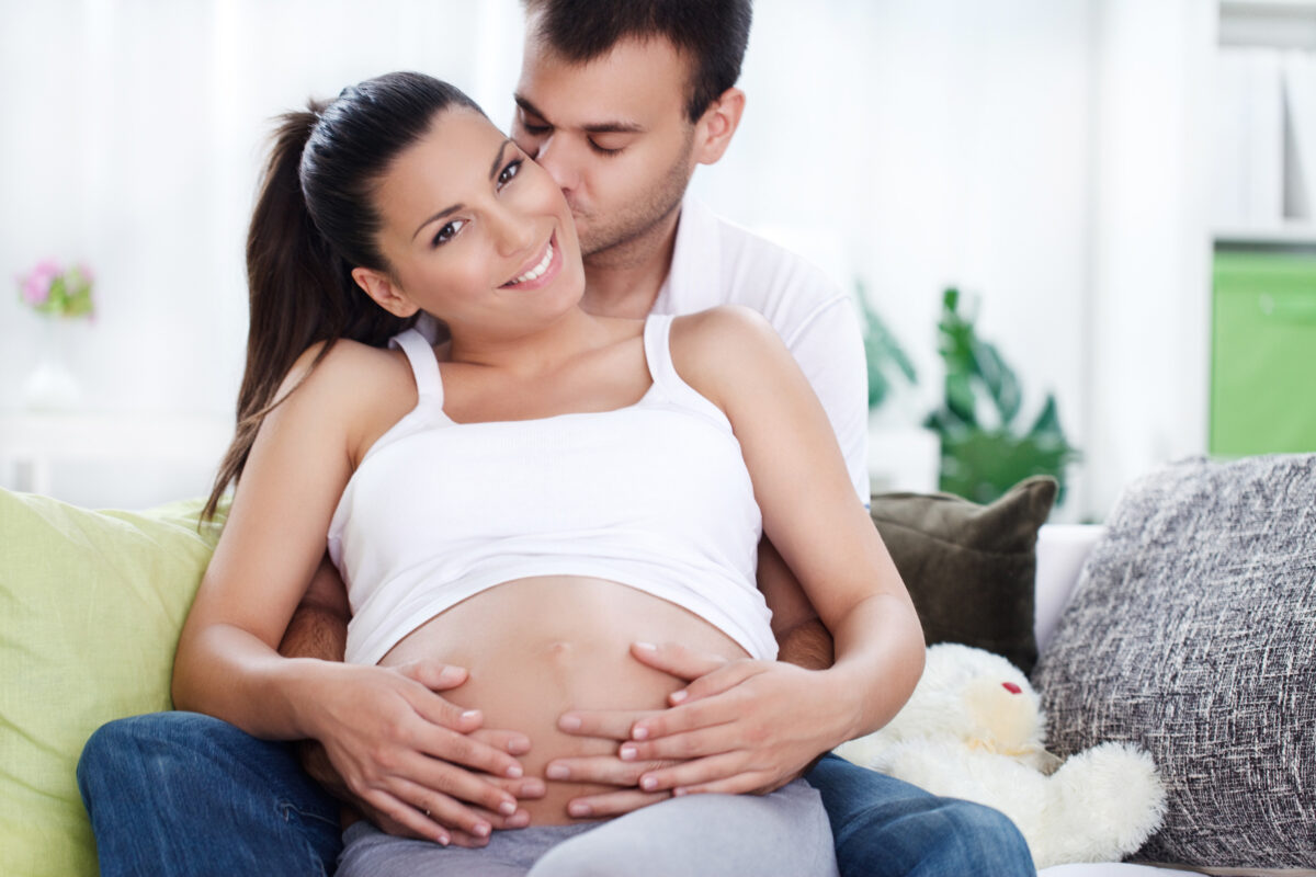 Pareja feliz esperando un bebé en casa