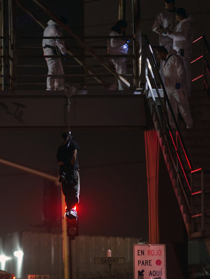 The body of a man hangs from a bridge in Tijuana, northwestern Mexico, on late Nov 2, 2016. According to official estimates, 2016 has been the most violent year in Tijuana since 2010. / AFP PHOTO / GUILLERMO ARIAS