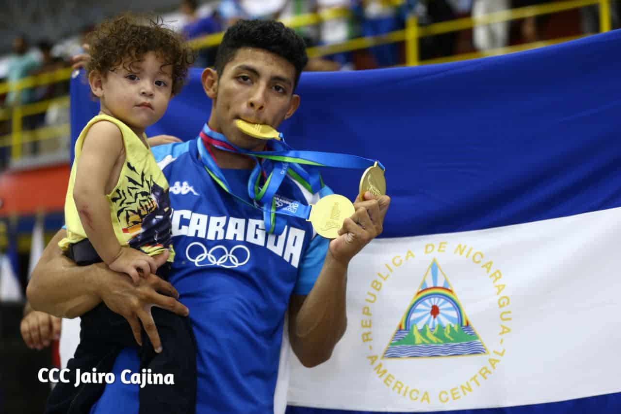 Orlando Vásquez posa junto a su hijo y las 3 preseas doradas conquistadas hoy