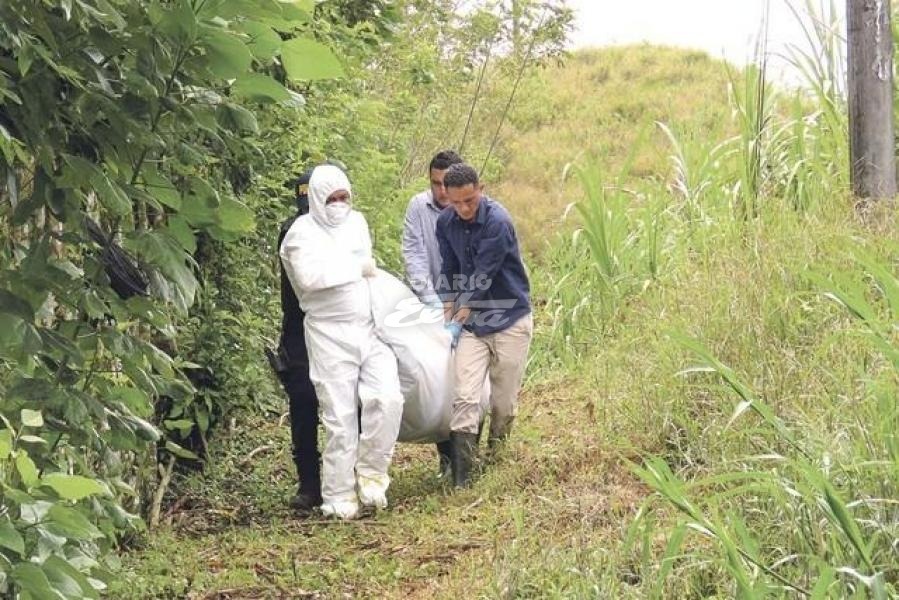 Forenses retiran los cuerpos en la escena del crimen. Foto cortesía de Diario Extra