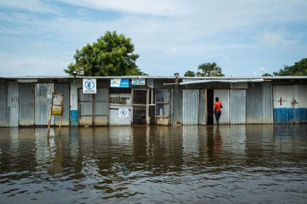 Una mujer ingresa a una tienda en medio de una calle inundada por el desborde del Río Nilo en Sudán