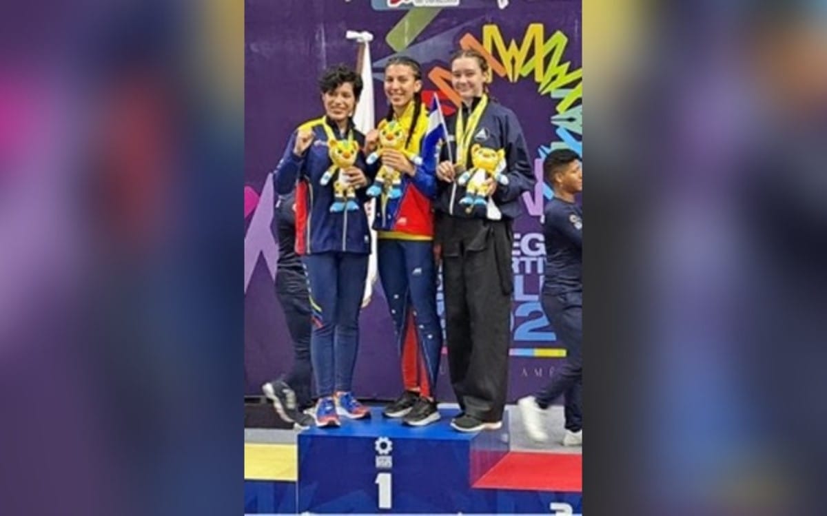 La ganadora de la medalla de oro (centro) en la categoría de combate de Kenpo Karate invita a la medallista de plata ya la medallista de bronce (Orla) a subir a la plataforma de la medalla de oro con ella