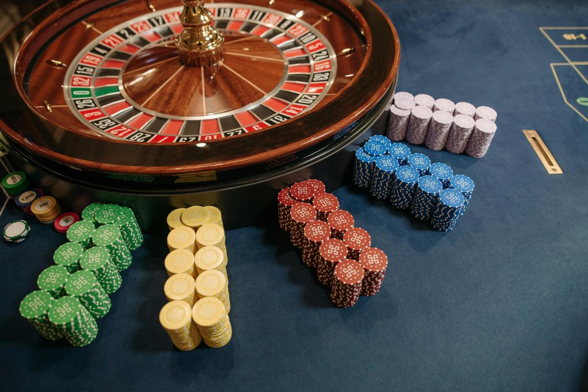 Ruleta de casino con fichas de colores apiladas. Por Pavel Danilyuk